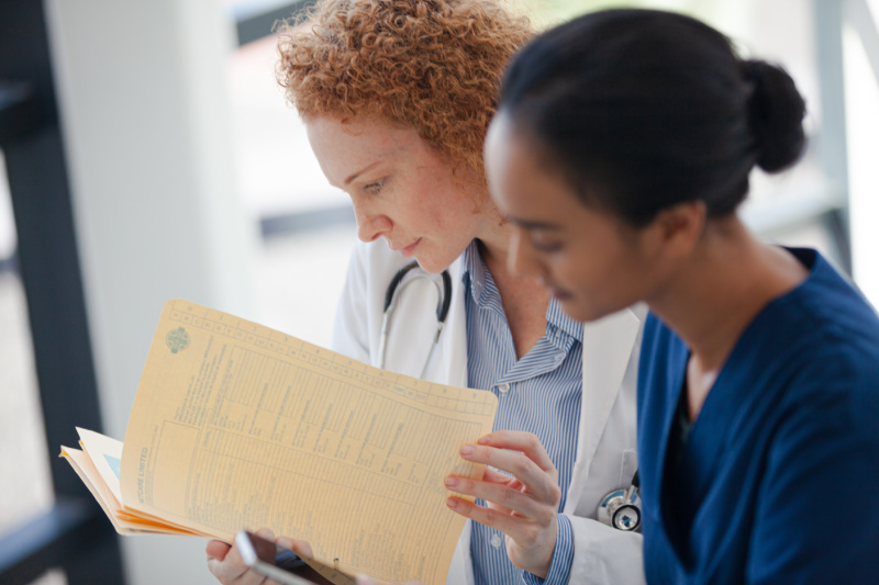 Nurse and doctor review a patient file